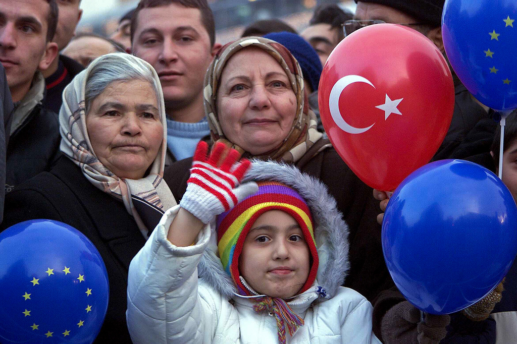 Turkey's EU Accession. A child and two older women hold turkey balloons.